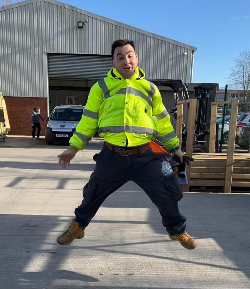 A person excitedly jumps outside a warehouse